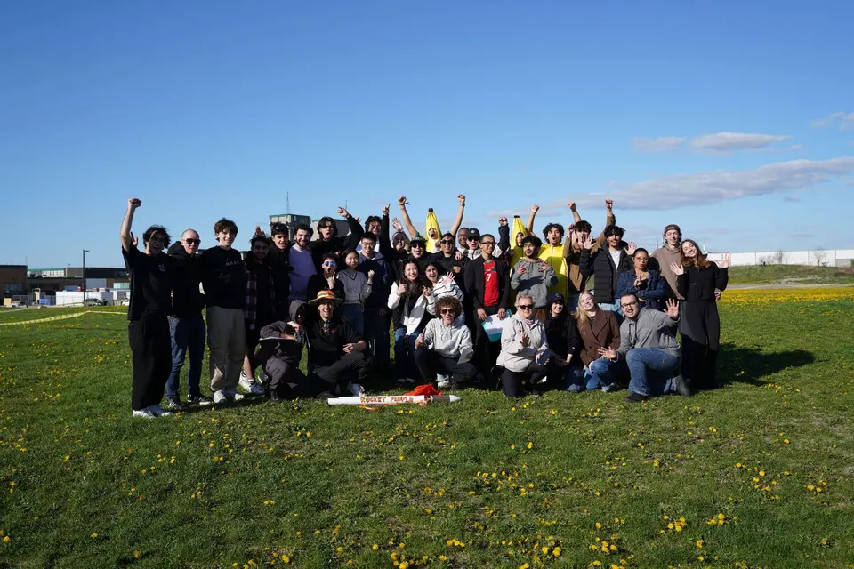 MARS members gathered with their rocket on a grassy launch field