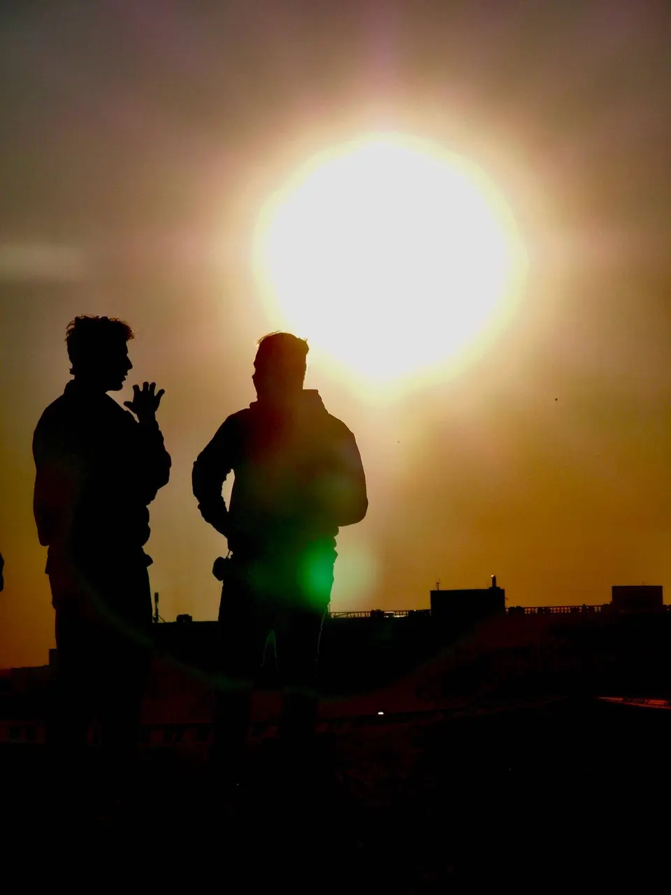 Two people silhouetted against the low sun